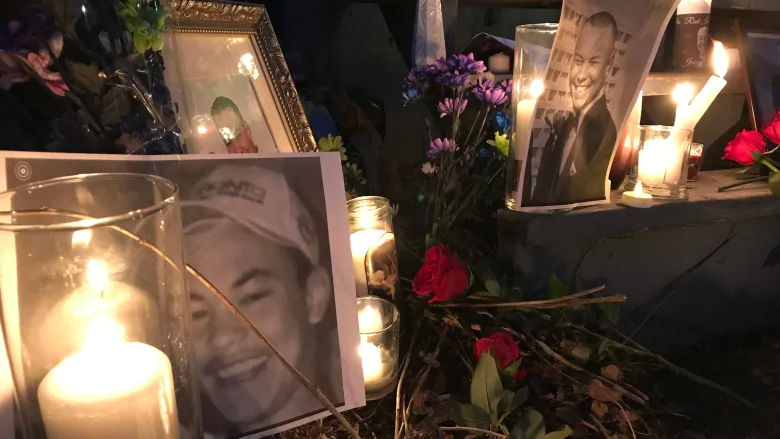 Flowers, candles, and photos at a vigil