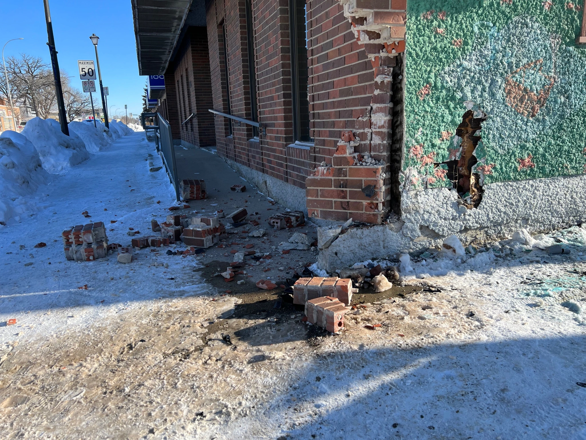 The corner of a building that has been partially destroyed by a police car crash