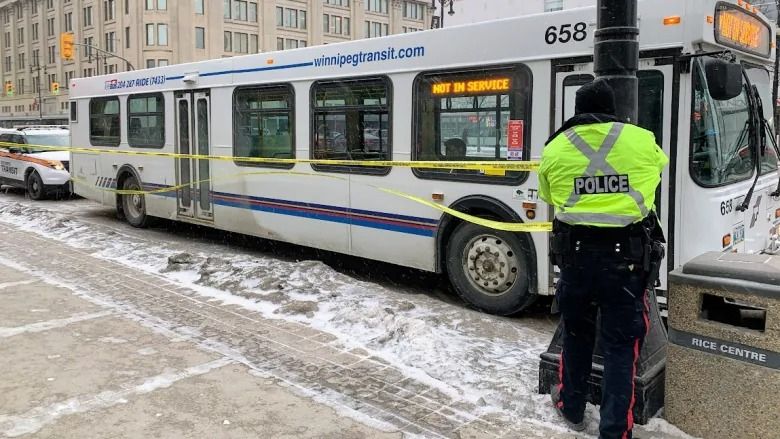 Photo of Winnipeg Police officer surrounding a Winnipeg Transit bus with yellow crime scene tape.