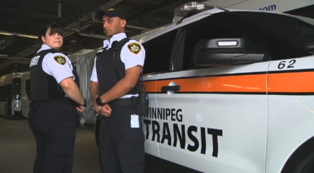Photo of two Winnipeg Transit inspectors posing outside of their vehicle while wearing new slash-resistant vests.