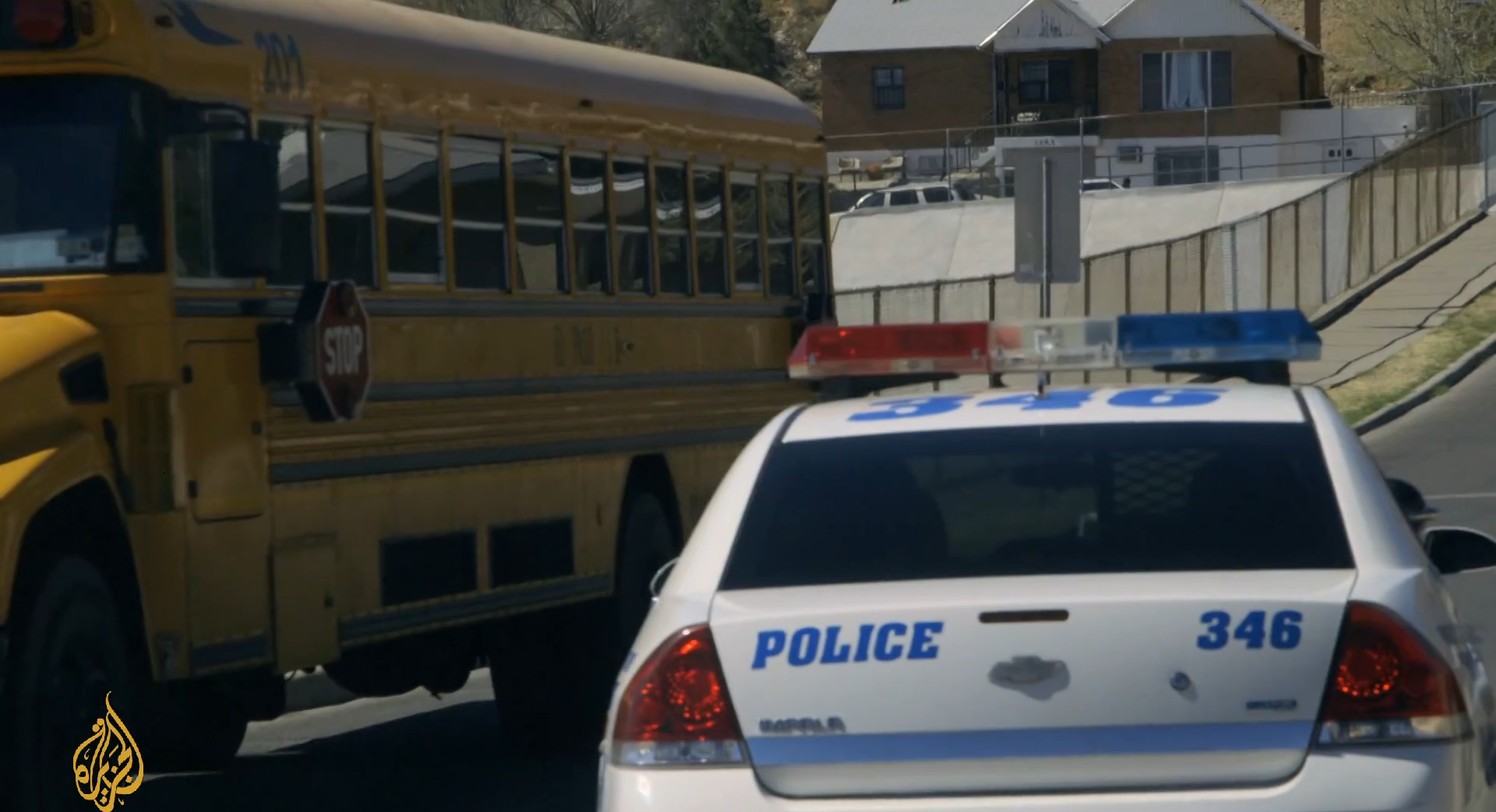 Photo shows a police cruiser driving in the opposite direction of a school bus