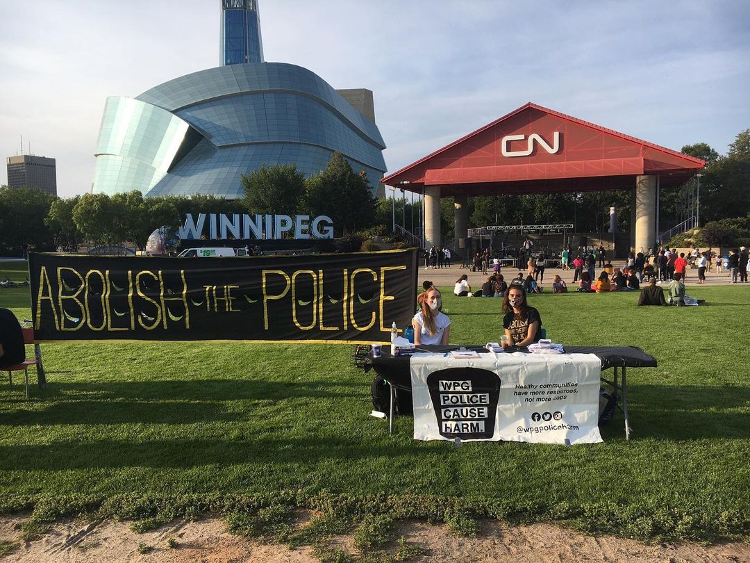 two members of winnipeg police cause harm at a police abolition info booth at the forks